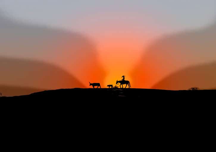 Cowboy riding into the sunset
